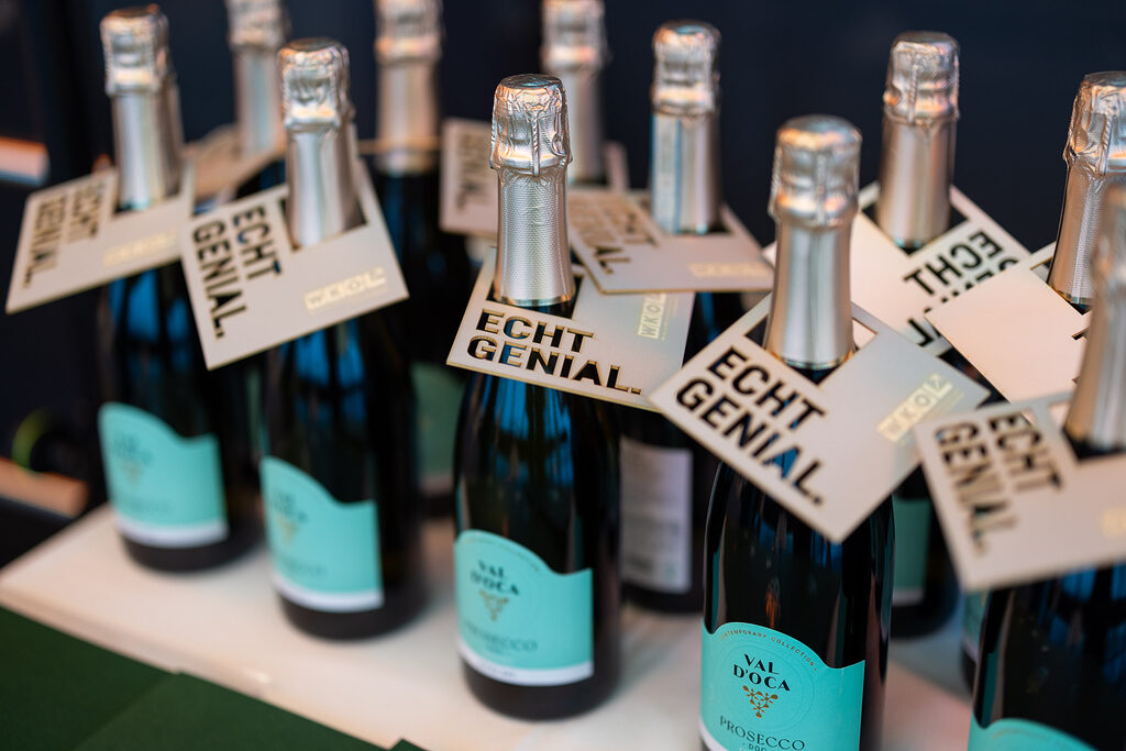 Prosecco-Flaschen mit echt genial Anhänger und Urkunden in grünen Hüllen